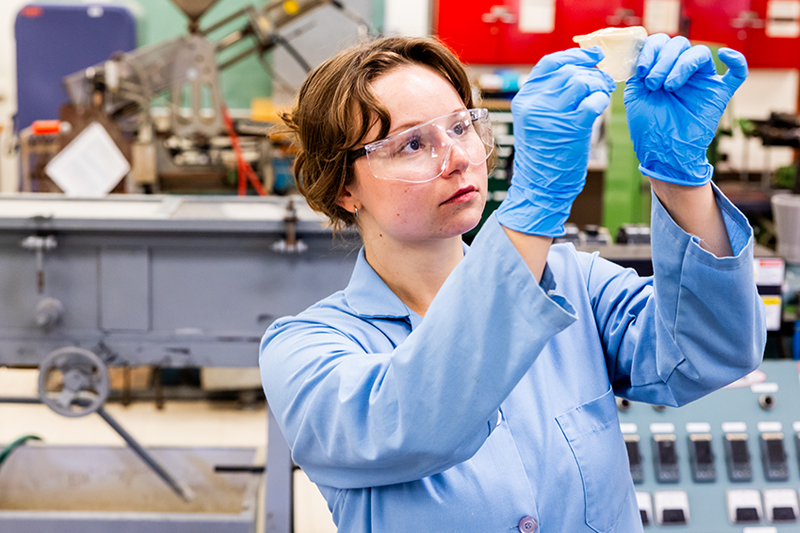 Researcher examines a transparent edible soy protein film in a laboratory.